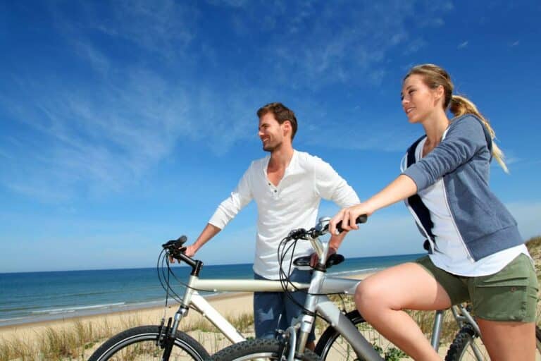 Happy couple with bikes on a beach