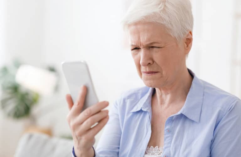 Older woman having trouble looking at her phone